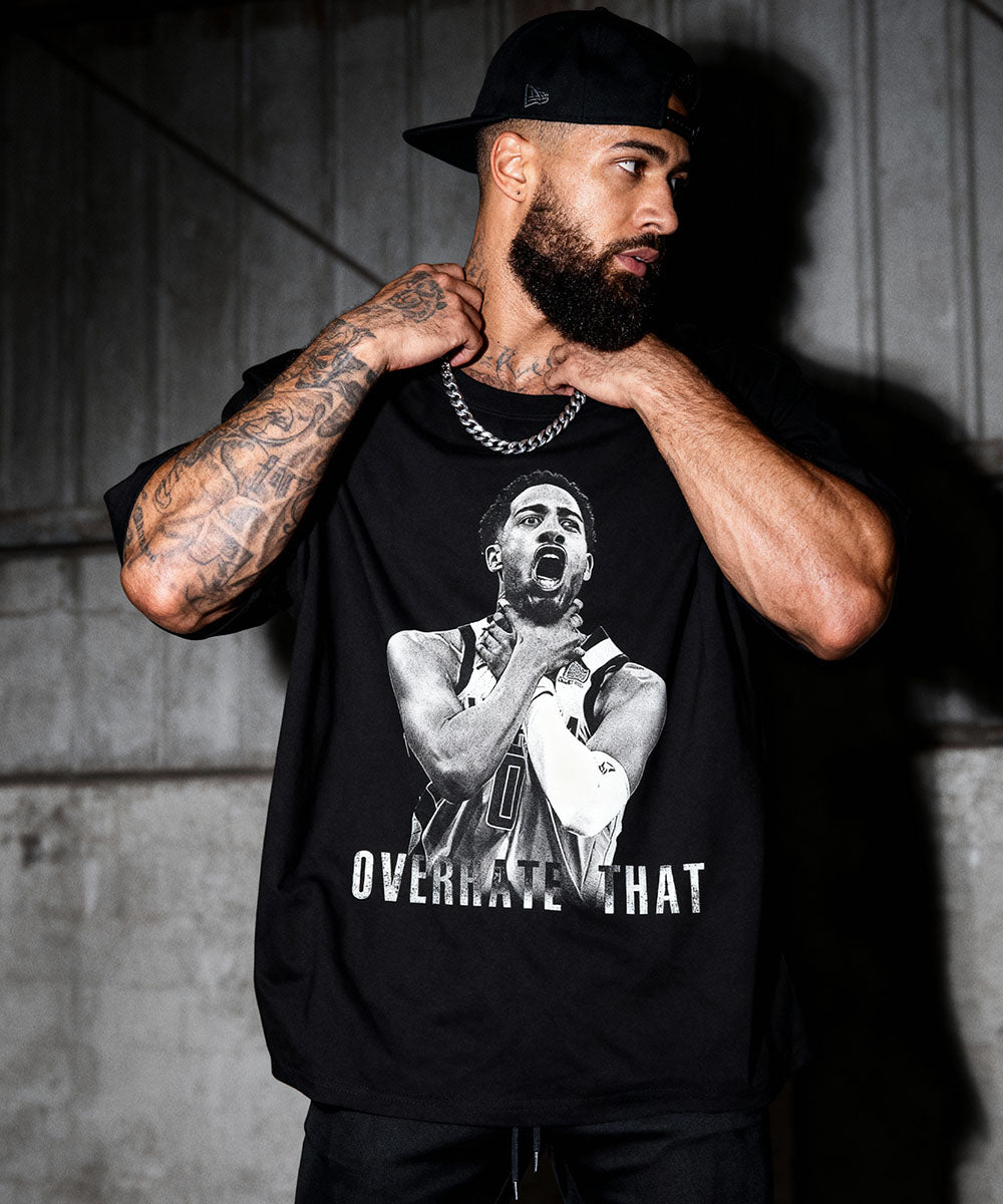 Model wearing Cruel Royalty Overrate This basketball graphic t-shirt — bold vintage sports streetwear collection